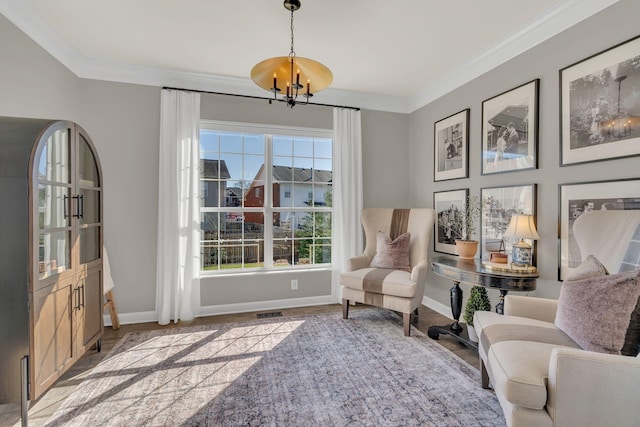 sitting room with an inviting chandelier, baseboards, and ornamental molding