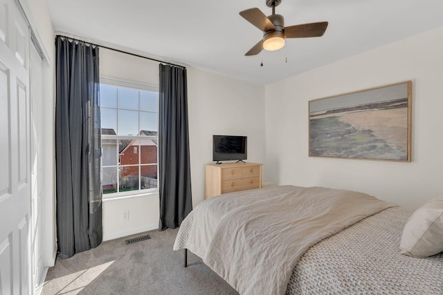 bedroom featuring ceiling fan, visible vents, and light colored carpet