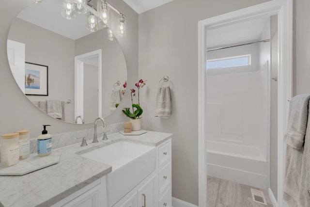 bathroom with shower / bath combination, visible vents, and vanity