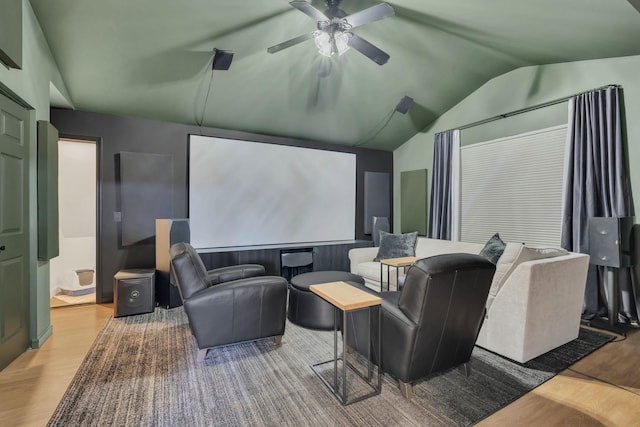 cinema room with lofted ceiling, a ceiling fan, and wood finished floors