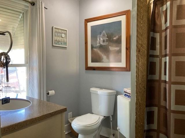 bathroom featuring a shower with curtain, vanity, and toilet