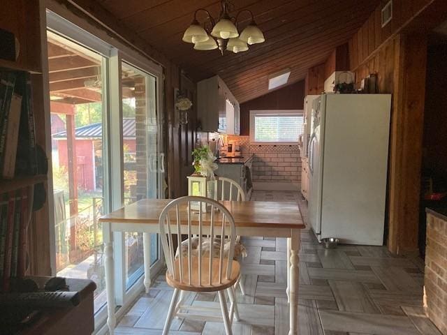 dining area with lofted ceiling, wooden ceiling, visible vents, and a notable chandelier