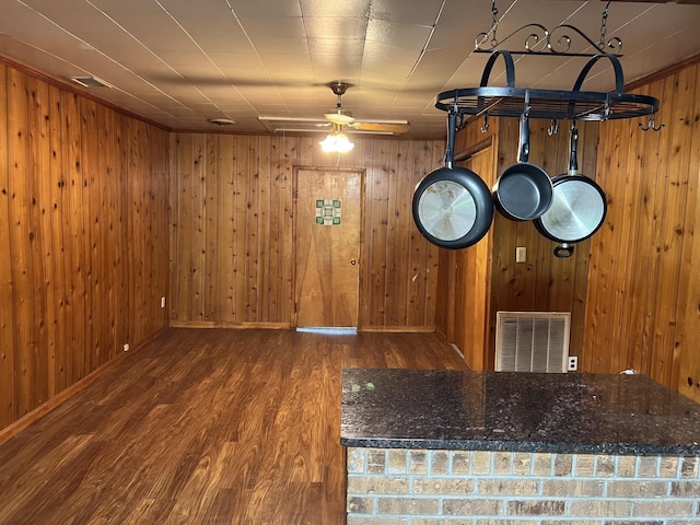 interior space featuring a ceiling fan, baseboards, visible vents, and wood finished floors