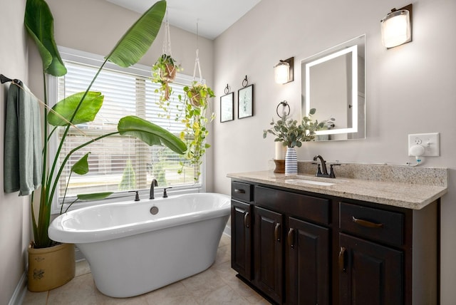 full bathroom featuring a freestanding tub, tile patterned floors, and vanity