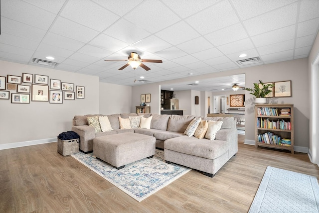 living room with visible vents, light wood-style flooring, and baseboards