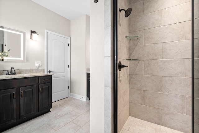 bathroom featuring tiled shower and vanity