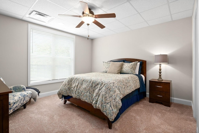 bedroom with carpet floors, baseboards, visible vents, and a drop ceiling