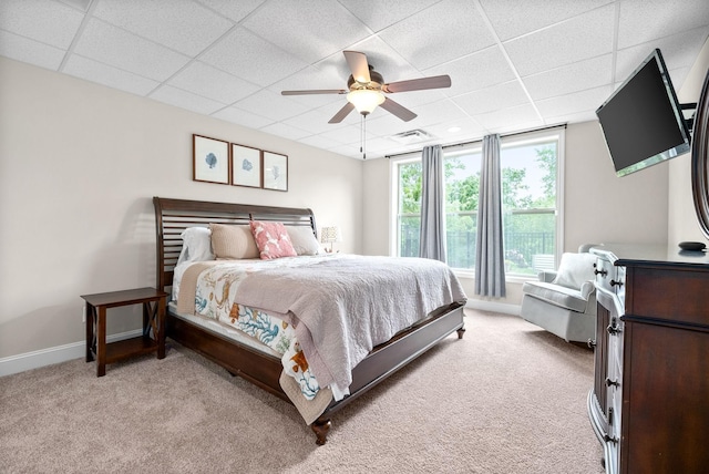 bedroom featuring a paneled ceiling, light colored carpet, and baseboards