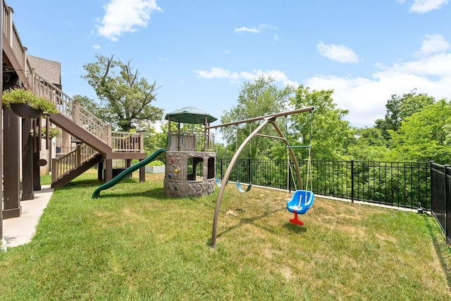 communal playground featuring a lawn and fence