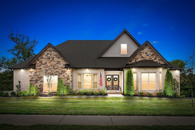 view of front of home with stone siding, a front lawn, and brick siding