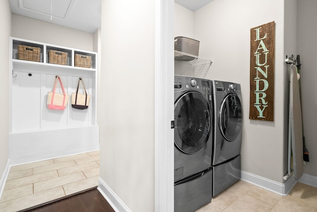 washroom featuring laundry area, attic access, baseboards, and washing machine and clothes dryer