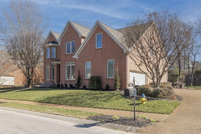 traditional-style house featuring an attached garage, driveway, brick siding, and a front yard