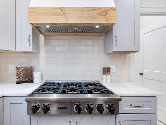 kitchen with white cabinetry, stainless steel gas stovetop, island range hood, and backsplash