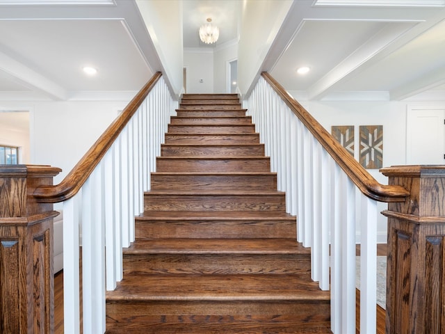 stairs with a bar, ornamental molding, and beamed ceiling