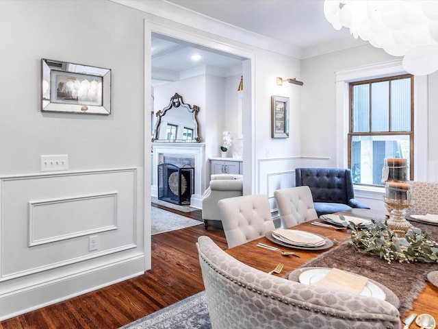 living area featuring dark wood-type flooring, a fireplace with flush hearth, and crown molding