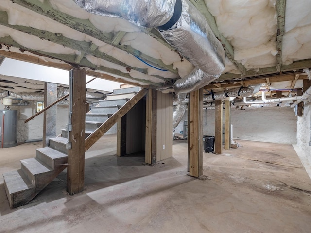 unfinished basement featuring water heater and stairway