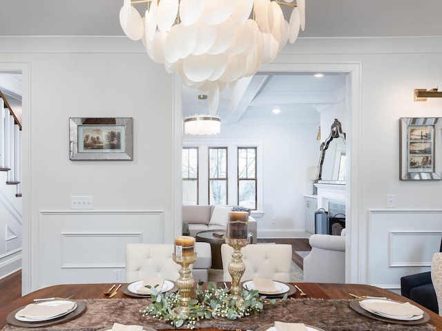 dining room with coffered ceiling, wood finished floors, stairs, a fireplace, and a chandelier