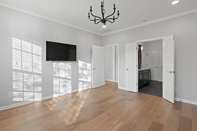 unfurnished bedroom featuring a chandelier, ornamental molding, wood finished floors, and baseboards