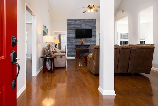 living room featuring a ceiling fan, a glass covered fireplace, baseboards, and wood finished floors