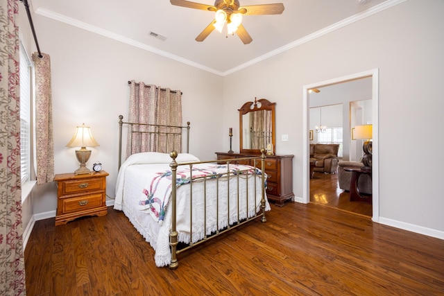 bedroom featuring ornamental molding, visible vents, baseboards, and wood finished floors