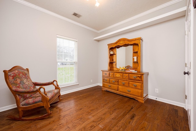 sitting room with baseboards, crown molding, visible vents, and wood finished floors