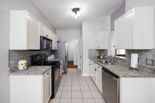 kitchen featuring black appliances, white cabinetry, a sink, and light tile patterned flooring