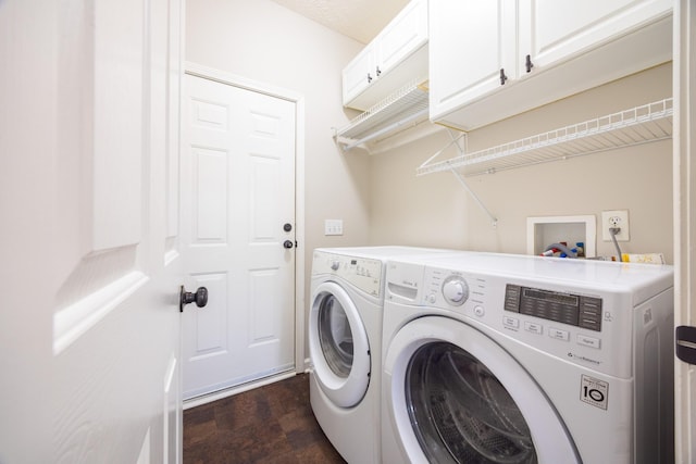 clothes washing area featuring dark wood-style floors, cabinet space, and separate washer and dryer