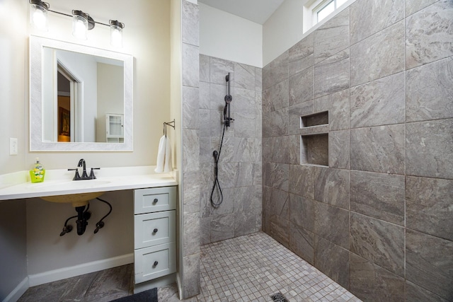 full bath with baseboards and tiled shower