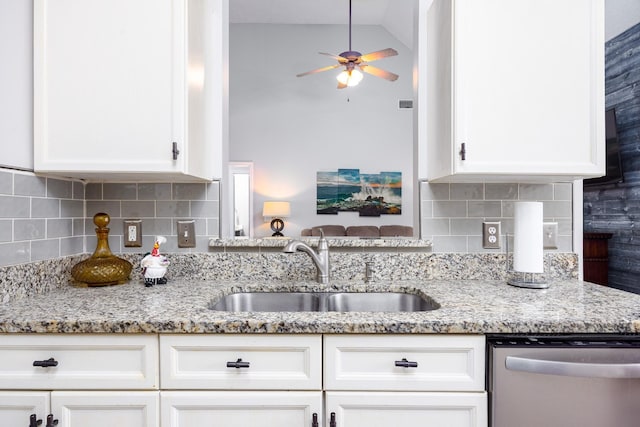 kitchen with dishwasher, a sink, white cabinetry, and light stone countertops