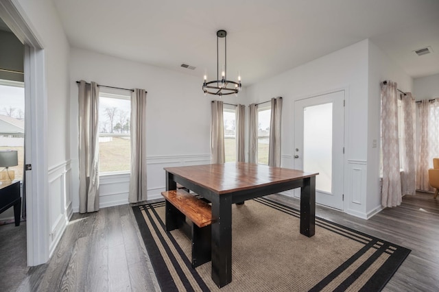 dining room with dark wood-style floors, a healthy amount of sunlight, and visible vents