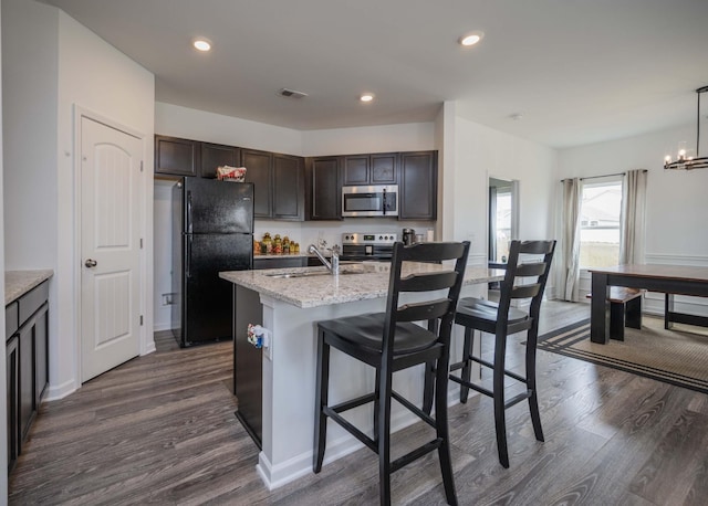 kitchen with stainless steel appliances, recessed lighting, dark wood-type flooring, a sink, and dark brown cabinets