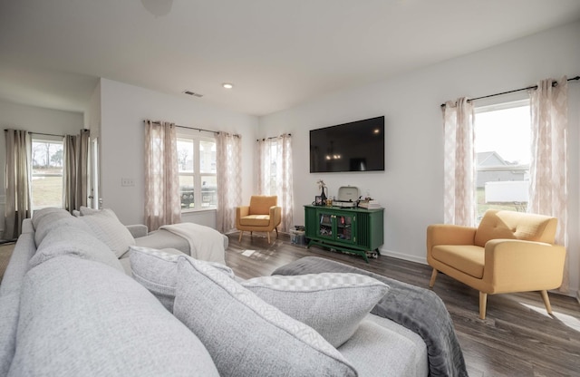 living room featuring baseboards, visible vents, wood finished floors, and recessed lighting