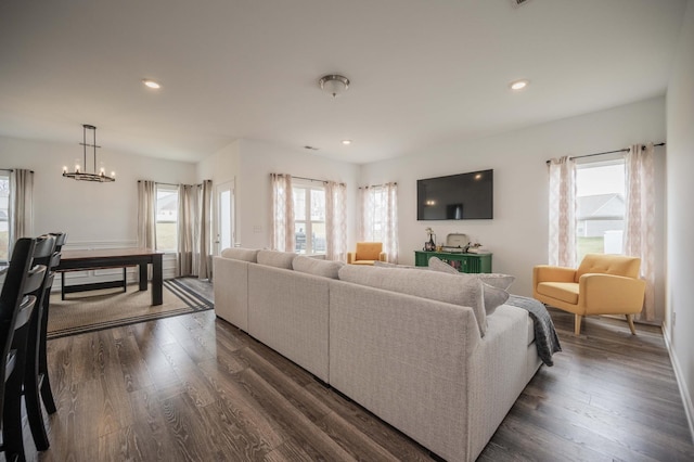 living room with dark wood-type flooring, an inviting chandelier, and recessed lighting