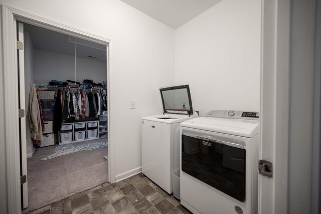 washroom featuring laundry area, stone finish floor, dark carpet, washing machine and clothes dryer, and attic access