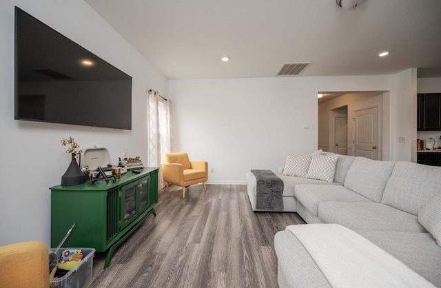 living room with baseboards, visible vents, wood finished floors, and recessed lighting