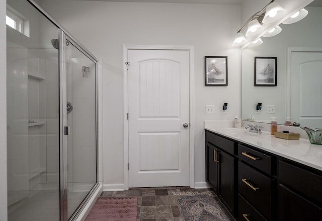 bathroom featuring a stall shower, vanity, and baseboards