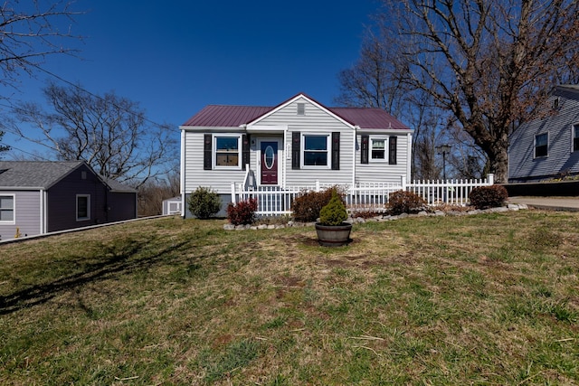 view of front of property featuring metal roof, a front yard, and fence