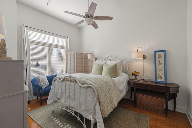 bedroom with wood finished floors, a ceiling fan, and baseboards