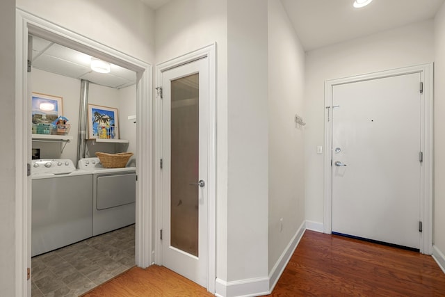 hallway with wood finished floors, baseboards, and separate washer and dryer