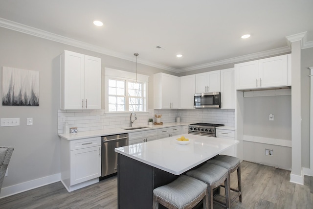 kitchen featuring appliances with stainless steel finishes, white cabinetry, and a sink