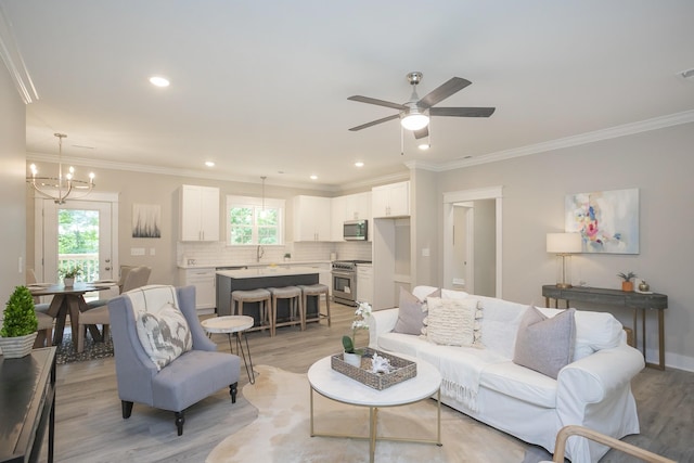 living room featuring light wood-style floors, crown molding, and recessed lighting