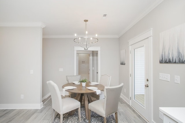 dining space with crown molding, light wood-style floors, a chandelier, and baseboards