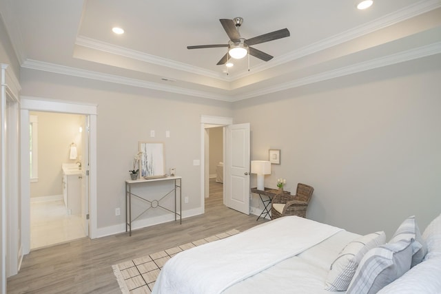 bedroom featuring light wood-type flooring, a raised ceiling, crown molding, and recessed lighting