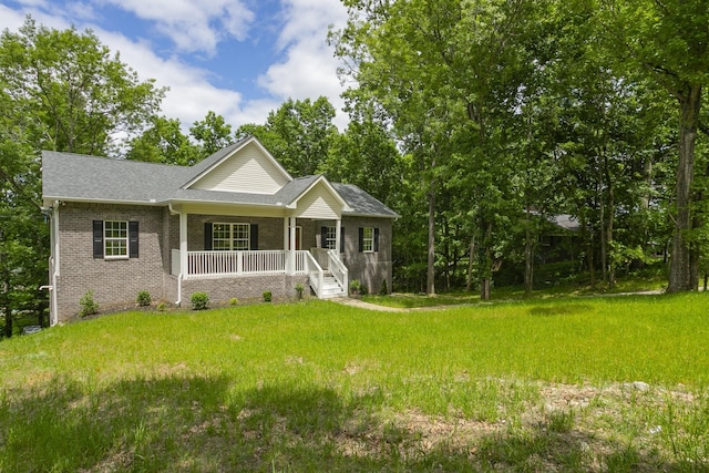 view of front of home featuring covered porch, brick siding, a front lawn, and a shingled roof