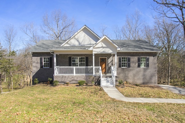 view of front of property featuring a porch, a front yard, and brick siding