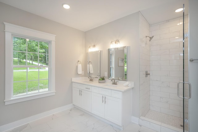 full bathroom featuring a stall shower, marble finish floor, a sink, and baseboards