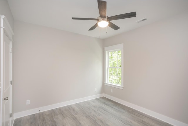 unfurnished room with a ceiling fan, visible vents, light wood-style flooring, and baseboards