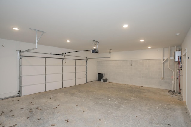 garage featuring water heater, recessed lighting, and a garage door opener