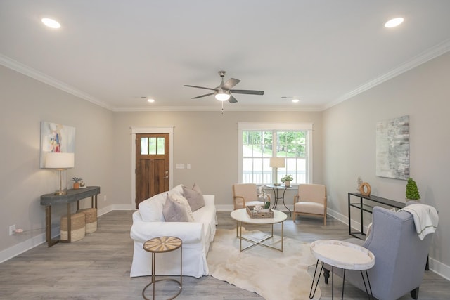 living room with plenty of natural light, ornamental molding, and wood finished floors