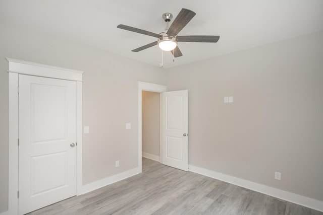 unfurnished bedroom featuring light wood-type flooring, a ceiling fan, and baseboards